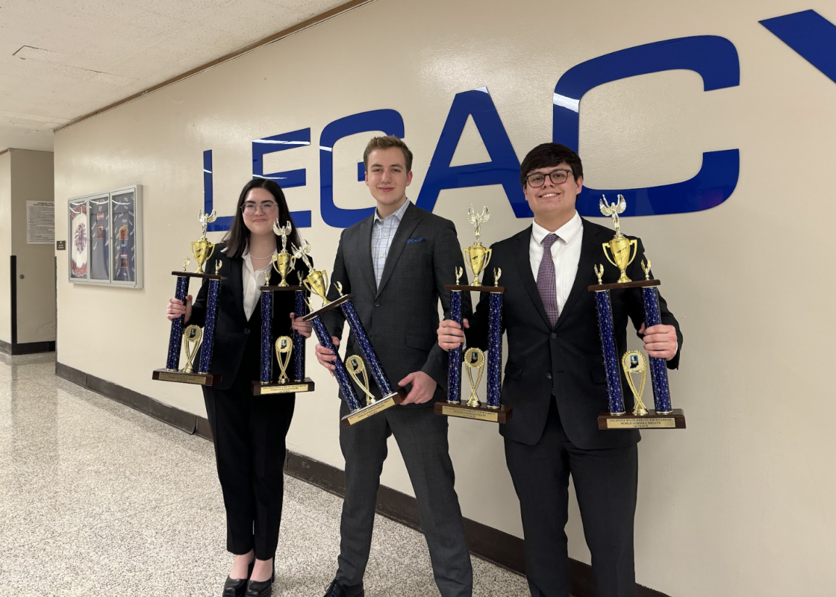 The State Champions in World Schools Debate, from left: Julia Hurley, George Madden and Johnny Beauchamp snap a picture with their trophies following a five to zero victory over Penn High School on Jan. 27. at Kokomo High School.