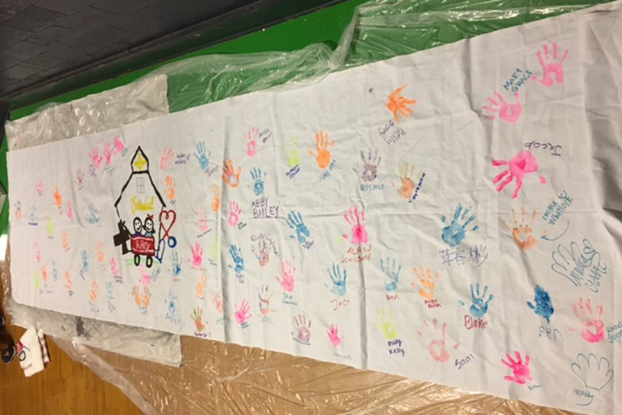 At the March 4 dance marathon in the auxiliary gym, participants added their hand prints to a banner. 