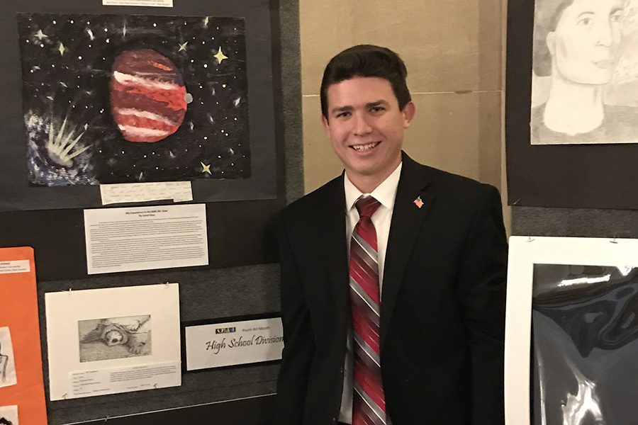 Senior Stephen Vukovits stands next to his drawing, which is part of an exhibit in the State House rotunda in Downtown Indianapolis.