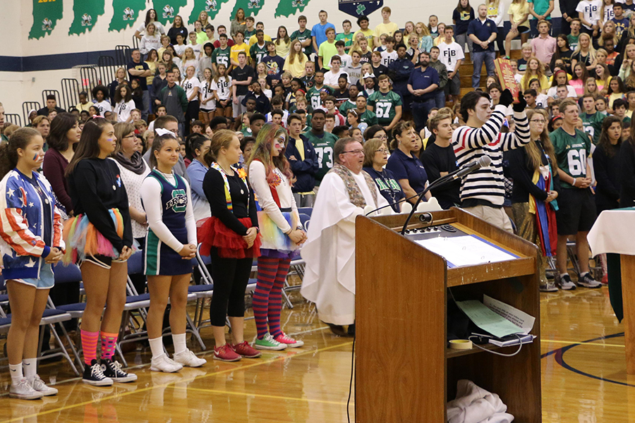 Surrounded by members of the liturgy planning committee, Fr. John Zahn celebrates Mass in the Welch Activity Center at the beginning of the 2016-2017 school year. 