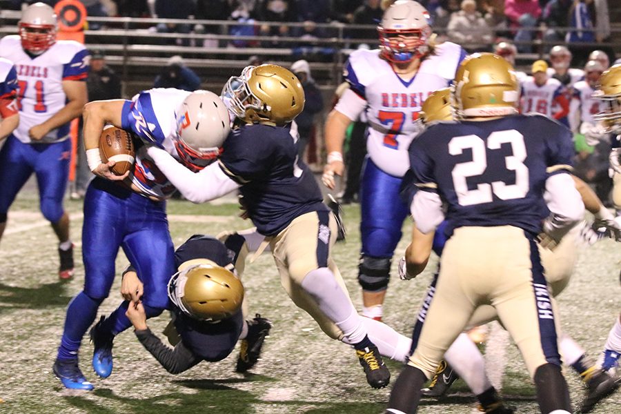 Senior Jackson Barrow and junior Johnny Leffel go high and low to make a defensive stop during the Sectional game against Roncalli.