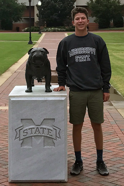 Austin poses with the statue of State's mascot, the bulldog.