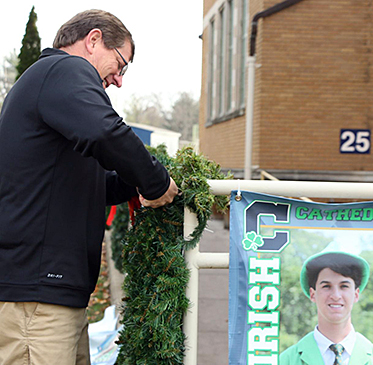 In one of his last jobs last year as the head football coach, Mr. Rick Streiff removes senior football posters from Loretto. 