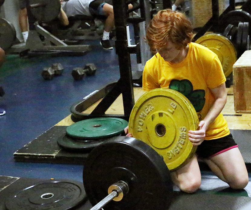 During her E period advanced physical conditioning class, senior Laurel Hotchkiss switches weights before her lifting session.