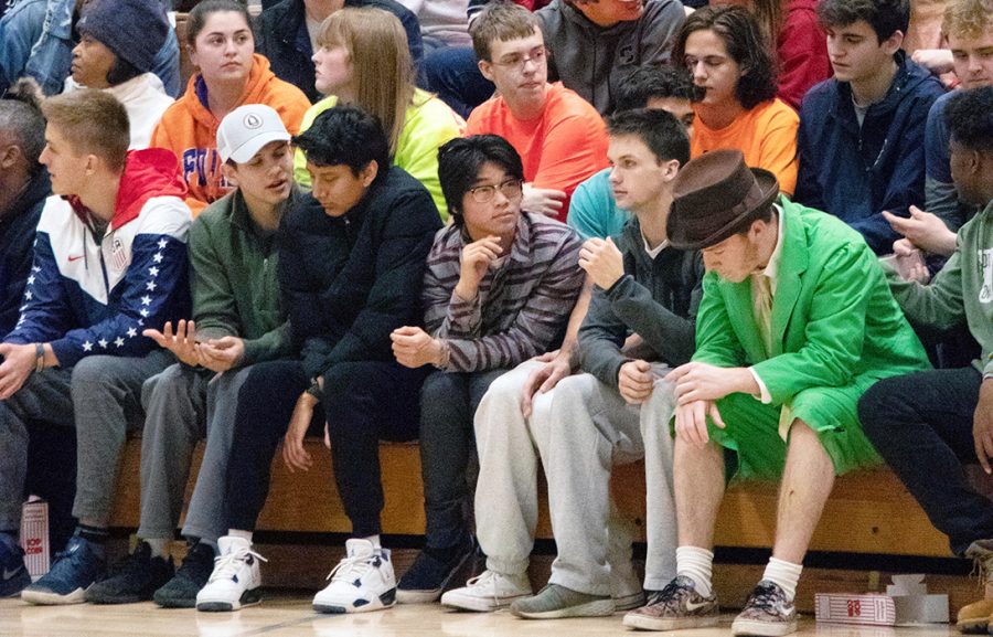 At a men's basketball home game against South Bend Riley, junior Andrew George sits in the second row of the student section during an Irish time out. George attends every home event that he can, always sporting the theme and cheering on the Irish.