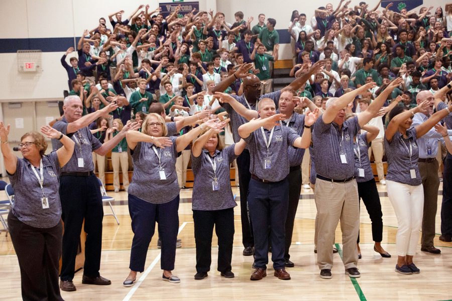 Director of Campus Ministry Mrs. Charlene Witka, far left, joins her fellow educators on the floor of the Welch Activity Center at the conclusion of an assembly. Witka is one of the organizers and leaders of the senior retreats. 