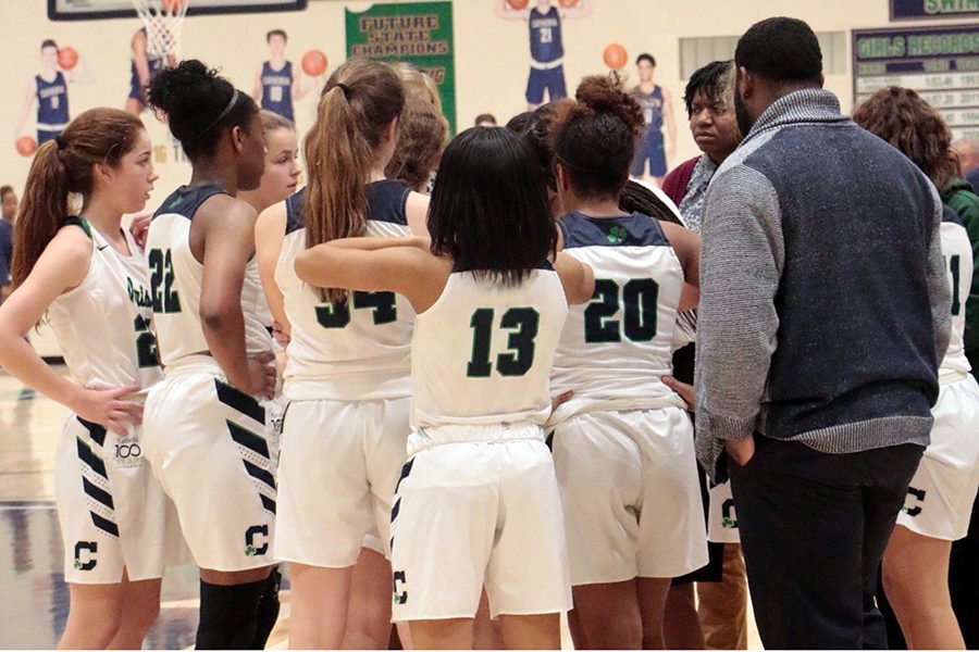 The women's varsity basketball team gathers during a timeout last season.