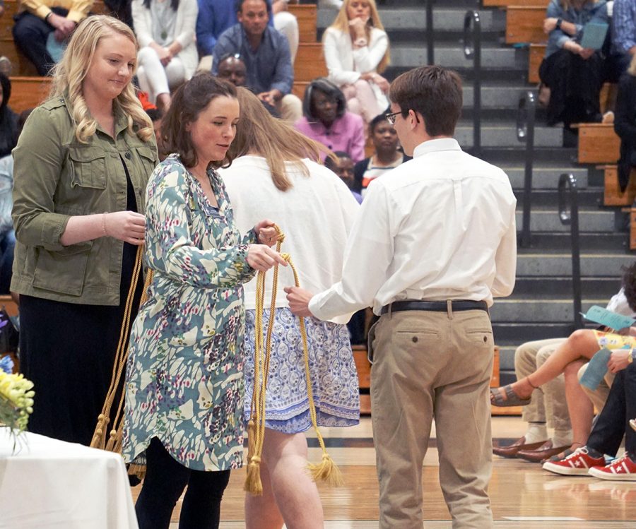 From left, counselors Mrs. Mary Hemer '09 and Mrs. Katz hand out membership cords to the National Honor Society inductees on April 28 in the Welch Activity Center. 