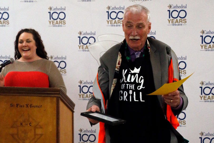 With Mrs. Jill Twilleager providing commentary, Dr. Tom Greer checks out some of the gag gifts he received at the year-end faculty and staff luncheon on May 23. 