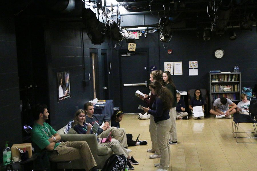 After school on Aug. 5, performing arts teacher Mr. Tristan Zavaleta, in green on the left, listens to students read their lines from the upcoming children's play. 