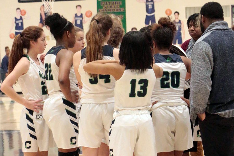 Tryouts for this season's women's basketball teams will be Oct. 21 and Oct. 22. During a regular season game last year, varsity players receive instruction during a timeout. 