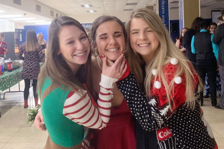 From left, freshmen Meghan Klenke and Allie Kaplan greet their peer mentor, senior Payton Synder, at the winter formal in December. 