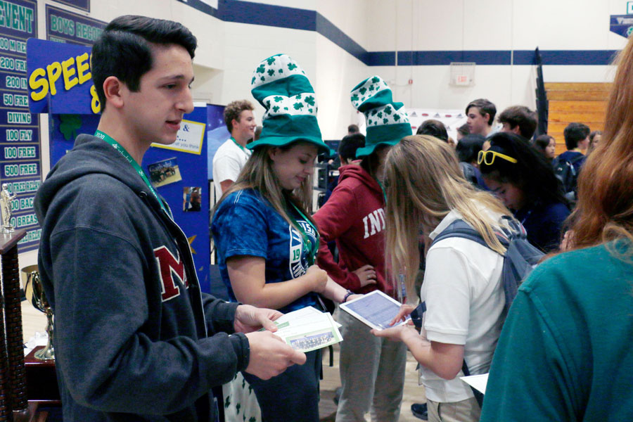 Senior Nick Grill hands out promotional material for the speech and debate team at the clubs and activities fair at the beginning of the school year. 