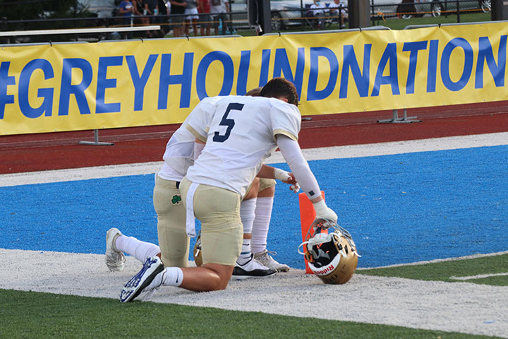 Varsity football players, including junior Hudson Miller (5), pause for a moment of reflection and prayer after the team’s 44-28 win at Carmel. Next up for the Irish is a short trip to Tech to play Whiteland in the Class 5A Regional championship game.