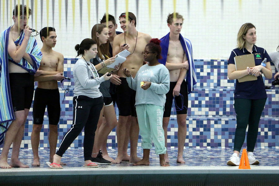 Swim team members gather on the pool deck during last year's regular season meet at Avon. 