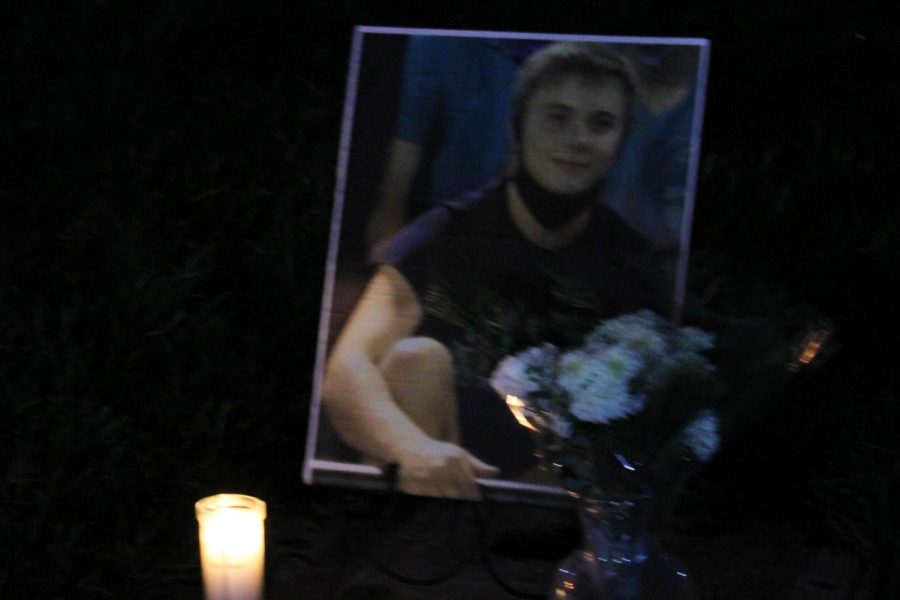 A candle illuminates Jon Knoll's photo at a memorial service on campus on Dec. 13.