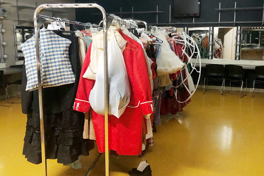 In the girls' dressing room, costumes for "Alice in Wonderland" are ready for their actors to wear. 