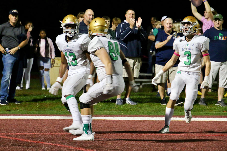 Junior Jaron Tibbs, senior Parker Spellacy and senior Daniel Hughes celebrate an Irish touchdown during the team's 45-21 win over Brebeuf Jesuit. 