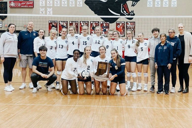 The women's volleyball team shows off its Sectional championship trophy. 