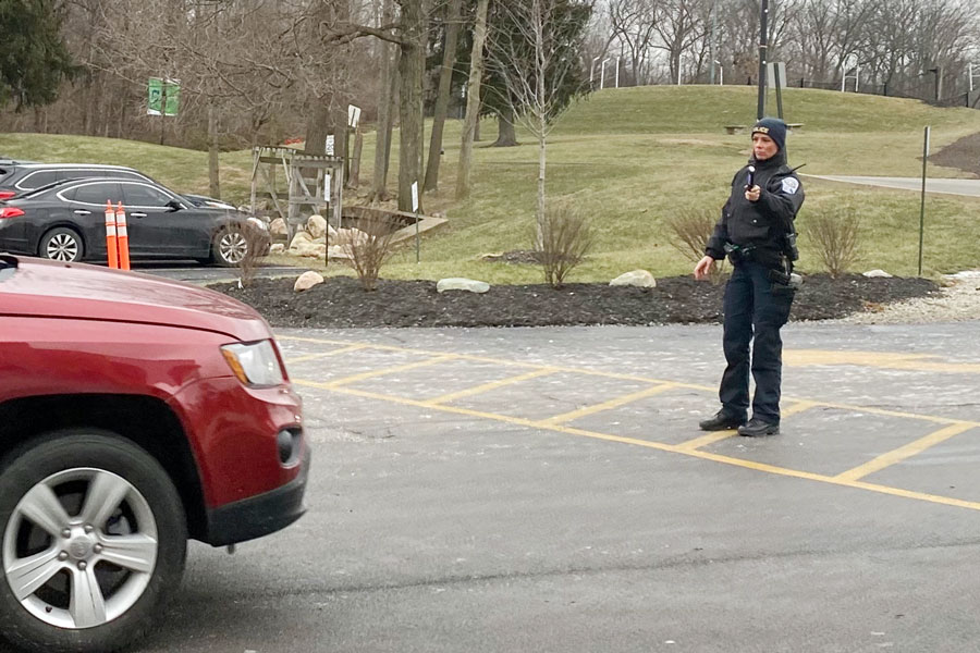 Office Tabetha Emenaker directs traffic after school. 