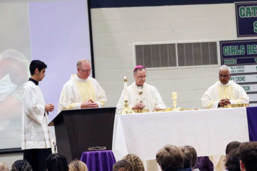 Archbishop Charles Thompson prepares the altar at the March 22 Mass.