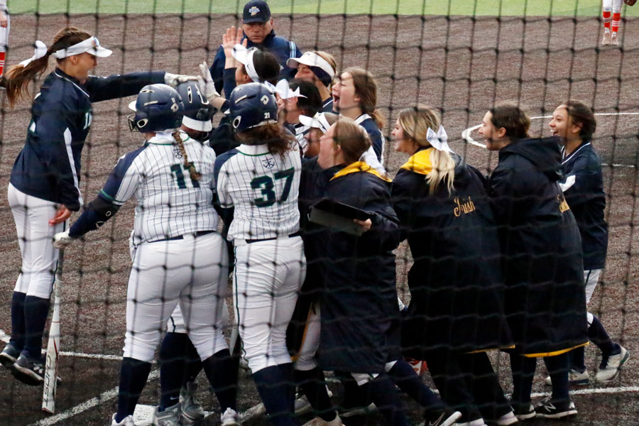 The varsity softball team surrounds freshman Maddie Liter after she hit her second home run of the game against Beech Grove.