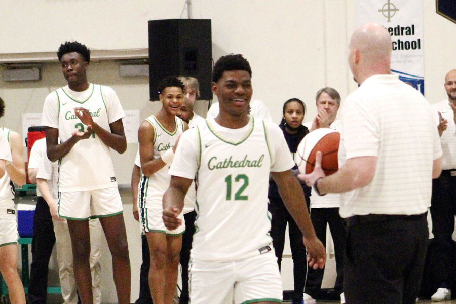 The men’s varsity basketball team’s regular season game against Carmel is paused so that Head Coach Mr. Jason Delaney can present the game ball to senior Tayshawn Comer after Comer scored his 1,000th career point. Comer would go on to set the school’s all-time scoring record and lead the team to the Class 4A State championship. 