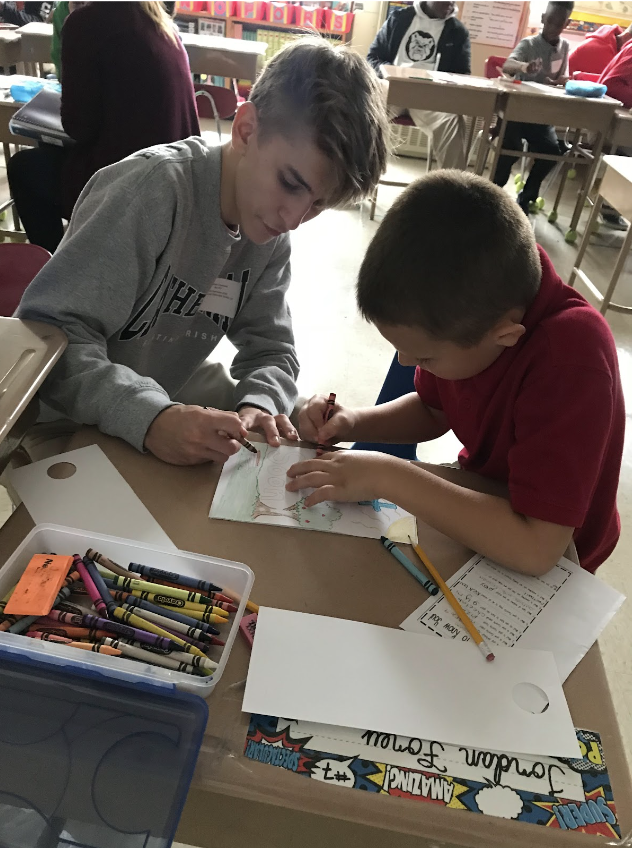 Cathedral student seen coloring with a kid at the Anna Brochhausen school 88.