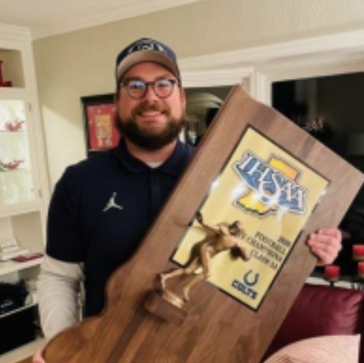 Mr. Cannaday is all smiles posing with the football state championship.