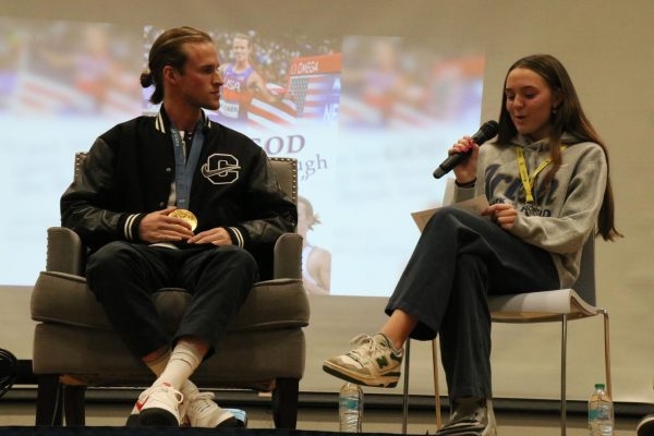 Cole Hocker sits on stage with junior Camille Spencer. Camille, and three other members of the track and field team, sat with Hocker and asked him a serious of random, sometimes humorous, questions.