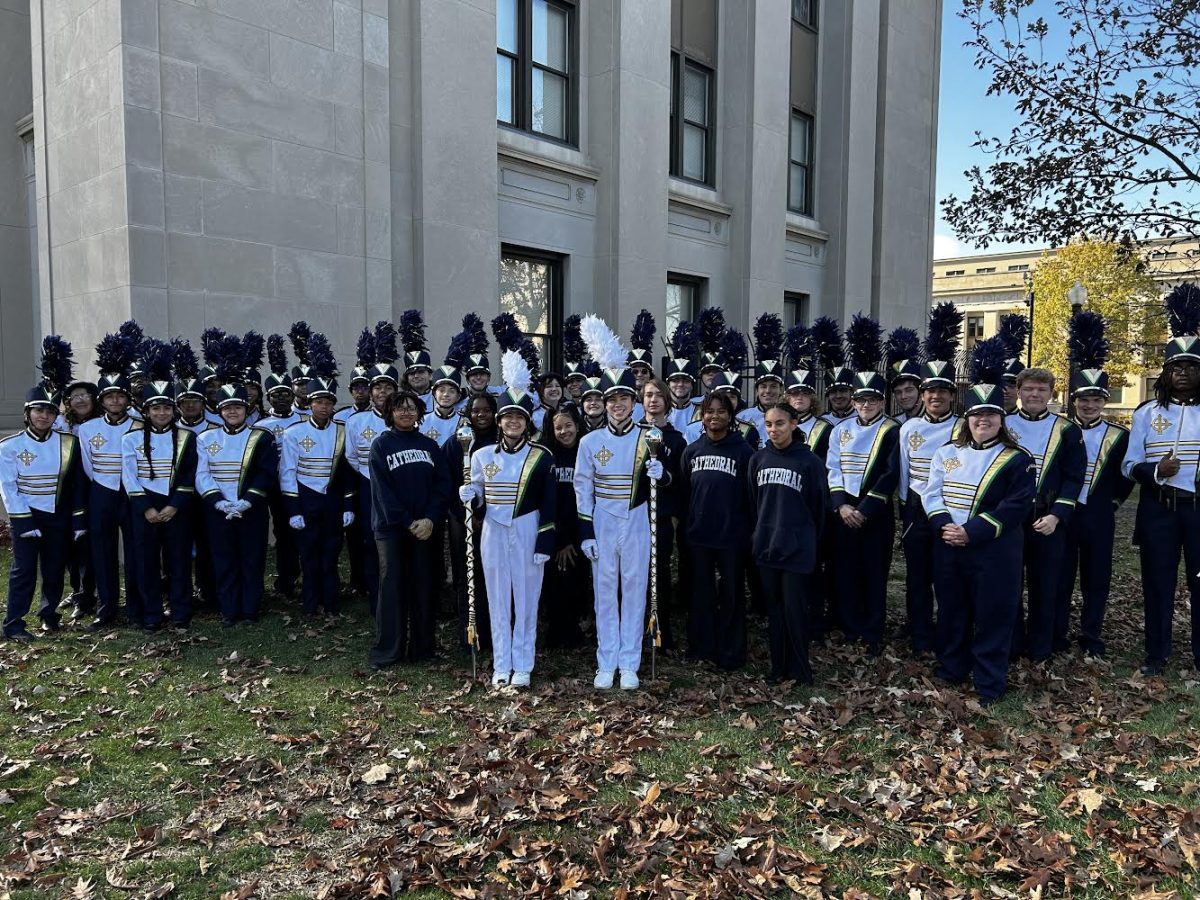 Cathedrals Pride of The Irish Marching band unite after performing. Band members traveled downtown for a veterans day parade. The band members stand close together for a picture after honorably performing. 