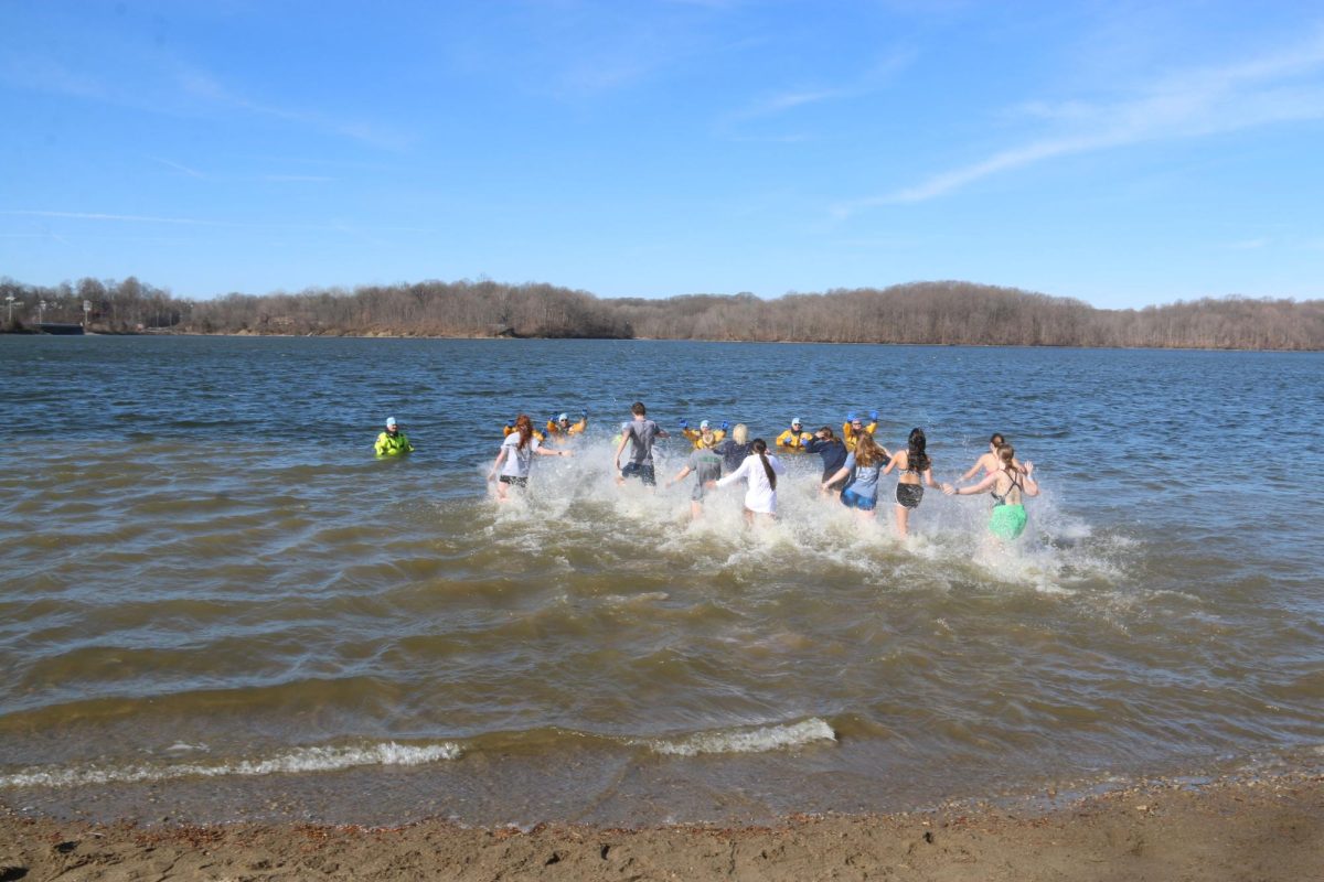 Cathedral students and staff take off toward the firefighters during the annual Polar Plunge. Every person plunging was asked to high five as many firefighters as they could before exiting the water.